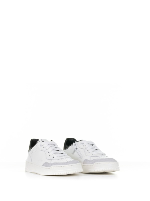 White leather sneaker with black heel